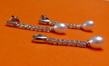 Afbeelding van “Pearl drop” set van hangertje en bengelende oorbellen in sterling zilver, een rij ronde kubiek zirkonia afgewerkt met één enkel zoetwaterparel