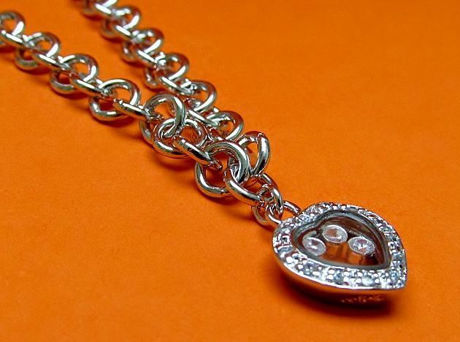 Picture of “Playful” bracelet in sterling silver, rolo link chain with heart charm outlined with cubic zirconia and containing floating zirconia