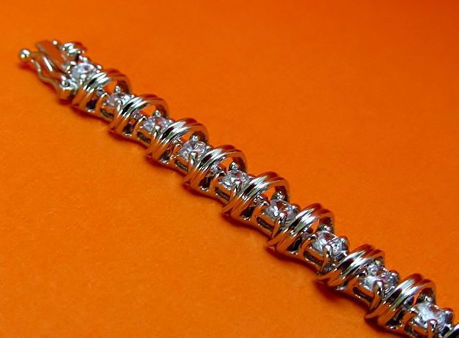 Afbeeldingen van “Spiralend in zirkonia” tennisarmband in sterling zilver, een rij ronde kubiek zirkonia in chaton zetting afgewisseld met 