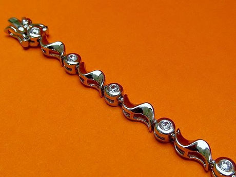 Afbeeldingen van “Golven van zirkonia” tennisarmband in sterling zilver, ronde kubiek zirkonia afgewisseld met zilveren golven